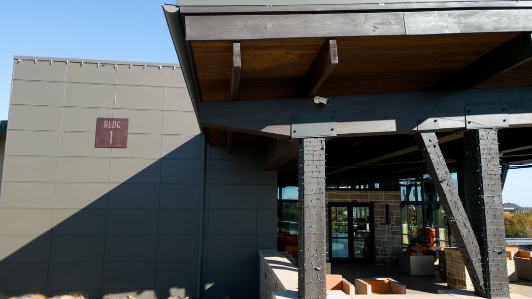 Building exterior with "Block 1" sign, showcasing modern architecture and outdoor seating area.