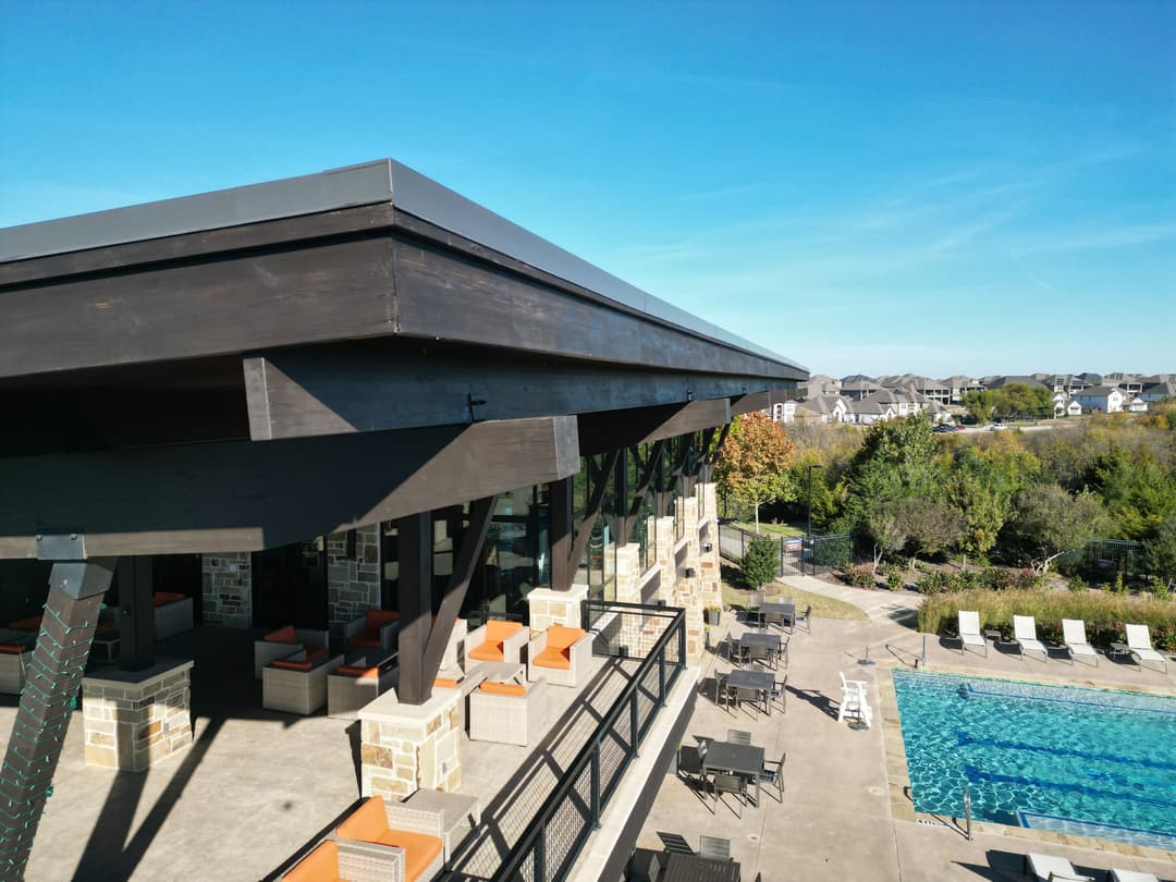 Modern outdoor lounge area with a pool, featuring stylish furniture and scenic landscaping.